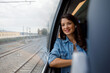 © Jovo Jovanovic/Stocksy - Smiling thoughtful commuter looking through window from train