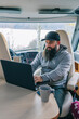 © Daniel Gonzalez/Stocksy - A man in a motorhome with a computer