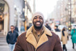 © Pedro Merino/Stocksy - Portrait of a smiling black man wearing a beanie