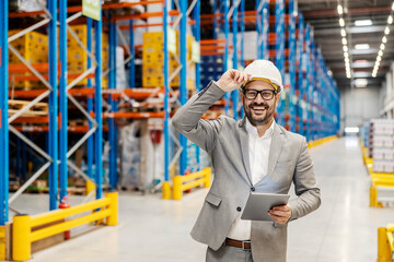 Wall Mural - A happy warehouse manager is tracking shipment and doing logistic while smiling at the camera.