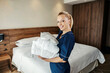 © Dusan Petkovic - Portrait of a chambermaid bringing bathrobes into a hotel room.