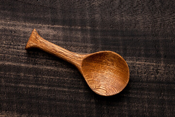 Wall Mural - Wooden spoon, kitchen utensil on dark rustic background