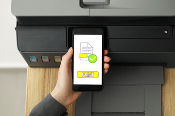 Woman using printer management application on smartphone indoors, closeup. Image on device screen.