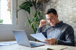 © Daniel - Excited business man student reading postal mail letter overjoyed by great news, happy male winner holding paper bill with loan approval celebrate taxes refund receive salary rise payment sit at desk.