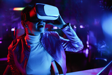 smiling trendy female testing out virtual reality in office