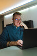 © Dusan - A young man is using his laptop at night for business or studying