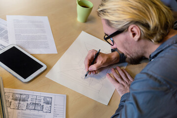 Close up hand drawing industrial design engineering interior paper.  Male engineer architect blueprints laying on table, use pencil. Banner  focus on hands architect sketch project on blueprint.