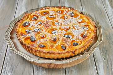 Wall Mural - Pie with apricots baked in the oven on wooden background