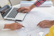 © mojo_cp - Architects interior designer hands working with Blue prints and documents for a home renovation for house design