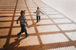 © Cavan Images - Back view of young children running on gazebo shadows