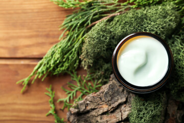 Wall Mural - Jar of cream with green moss and tree bark on wooden background