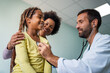 © NDABCREATIVITY - Male doctor examining a child patient in a hospital