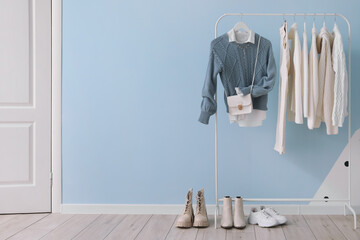 Wall Mural - Rack with stylish clothes, bag and shoes near color wall