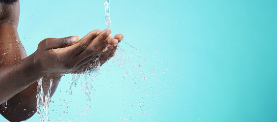 Water, black man and cleaning hands with mockup space, wash face and skincare isolated on blue background. Healthy skin, clean cosmetics and grooming, hygiene and beauty sustainability in studio