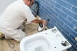 © Ladanifer - Unrecognizable senior plumber installer installing toilet drain flange in a house.