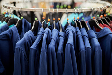 Wall Mural - blue sweatshirts on hangers in the store. Blue sweatshirts hang in a fashion store. Blue sweatshirts on a hanger in a clothing store.