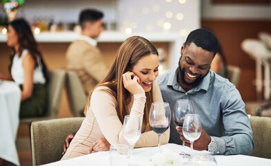 Date, laughing and interracial couple with wine in fine dining, luxury restaurant or valentines celebration together. Funny black man, happy woman and alcohol glasses for romance, rich or anniversary