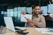 © Liubomir - Portrait of young successful financier paperwork inside office, man smiling and looking at camera shows graph with positive dynamics of economic profits, businessman at work with laptop.