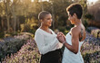 Woman, lesbian couple and holding hands in marriage for wedding with smile for LGBT relationship in nature. Happy gay married women touching hand and smiling for romance, vow or loyalty outside
