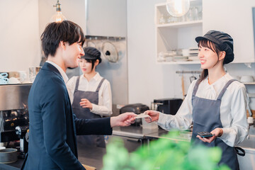 カフェでクレジット決済をするビジネスマン