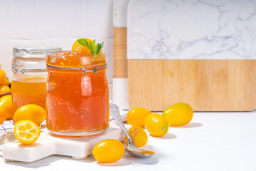 Wall Mural - Kumquat jam, homemade citrus tropical fruit marmalade, with fresh kumquat on a white marble table