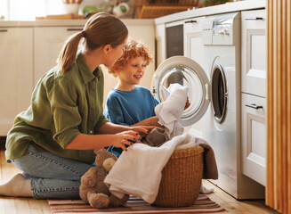 Son helping mom to load washing machine