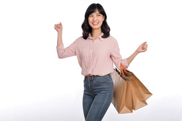 Young happy asian woman with casual shirt and denim jeans holding shopping paper bag isolated on white background