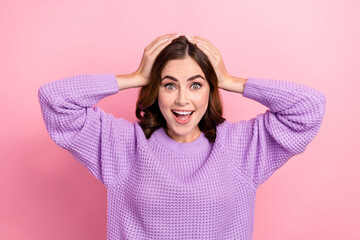 Poster - Photo of impressed ecstatic astonished woman with wavy hairstyle wear knit sweater hold arms on head isolated on pink color background