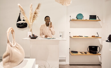 Wall Mural - Young African entrepreneur talking on a phone in her boutique