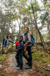 © Maskot - Side view of smiling woman standing on trail with son in forest during vacation