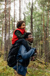 © Maskot - Side view of father carrying son on shoulder while exploring forest during vacation