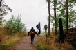 © Maskot - Rear view of son running towards mother on trail while hiking in forest