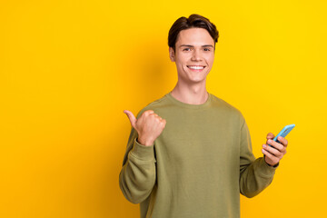 Canvas Print - Portrait of attractive positive person hold smart phone direct finger empty space isolated on yellow color background