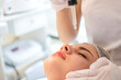 © Bojan - Beautician holding pipette and applying serum on face of woman in spa salon