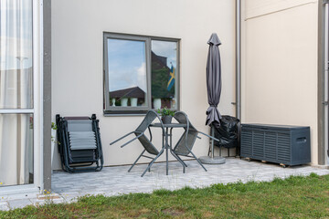 Wall Mural - Sweden, Knislinge – July 7, 2022: Chairs and table for relaxing outdoors on the terrace, veranda. Comfort relaxing zone. Cozy and comfortable atmosphere. Sunny summer day. Recreational area.