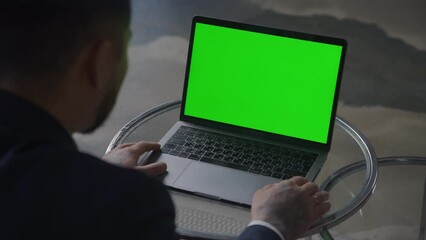 Laptop with chroma key green screen. Businessman looking
