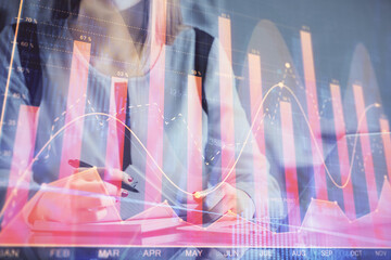 Poster - Double exposure of businesswoman hands typing on computer and financial graph hologram drawing. Stock market analysis concept.
