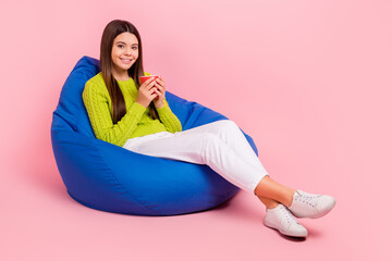 Canvas Print - Full length photo of cute young girl sit bean bag hold tea red mug relaxation dressed stylish green look isolated on pink color background