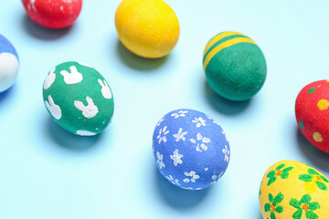 Wall Mural - Painted Easter eggs on light blue background, closeup