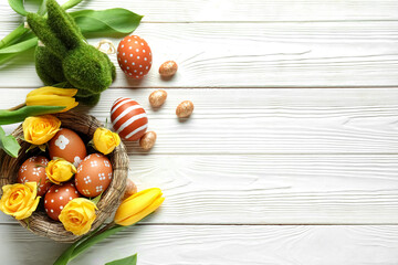 Canvas Print - Nest with beautiful Easter eggs, flowers and bunny on light wooden background