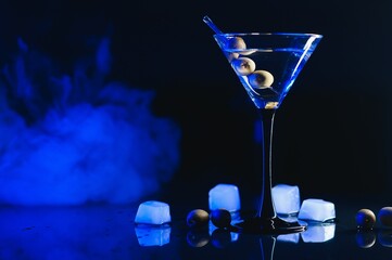 Wall Mural - Martini glass and olives on a black background with neon lights