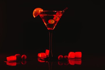 Wall Mural - Martini glass and olives on a black background with neon lights