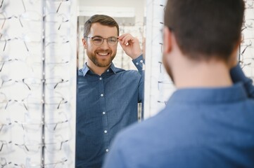 male client chooing new eyeglasses frame for his new eyeglasses in optical store