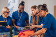 © Zamrznuti tonovi - Diverse volunteers working in a charity donation center and packing clothes and food