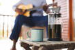 © Wavebreak Media - French press and mug on table over midsection of african american senior man playing guitar