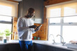 © Wavebreak Media - African american senior man wearing eyeglasses using mobile phone while standing by kitchen counter