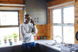 © Wavebreak Media - Bald african american senior man wearing eyeglasses talking over mobile phone by kitchen counter