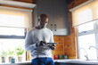 © Wavebreak Media - Bald african american senior man using digital tablet while standing by kitchen counter in log cabin