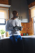 © Wavebreak Media - Bald african american senior man with digital tablet looking away while standing by kitchen counter