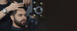 © New Africa - Professional hairdresser working with bearded client in barbershop, space for text. Banner design